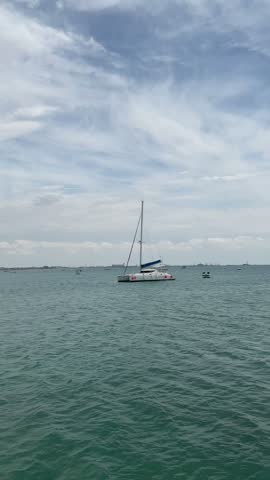 Catamaran sailing on the sea under a cloudy sky