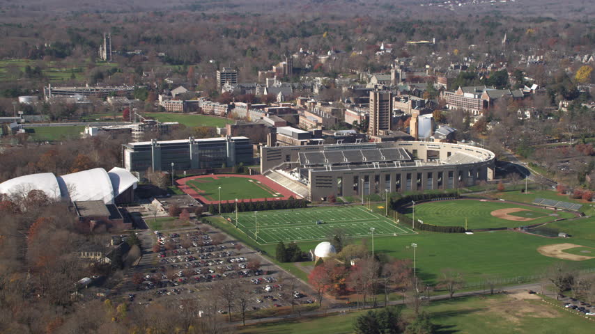 Aerial drone shot real-time moving forward princeton university campus stadium football baseball field school building autumn fall foliage princeton new jersey
