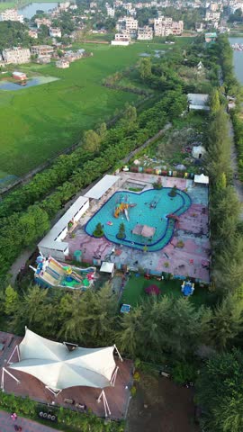 Aerial view of a large swimming pool complex in a recreation park straight down perspective of tropical style area featuring water