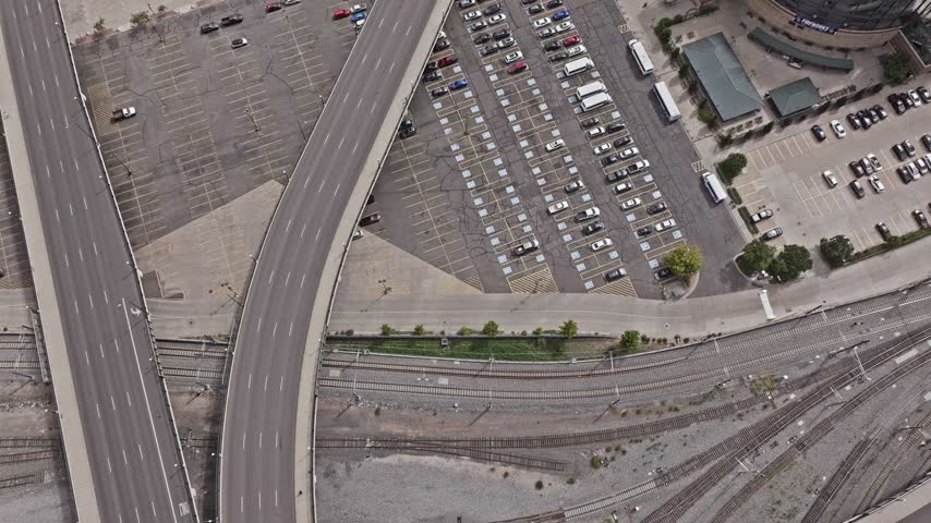Aerial view of a large parking lot adjacent to a highway and railway tracks in Denver, Colorado, United States.