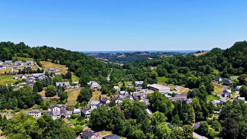 Aerial view of the village of Beost nestled in the green Pyrenees mountains with traditional houses and lush forests in Beost, Nouvelle-Aquitaine, France.