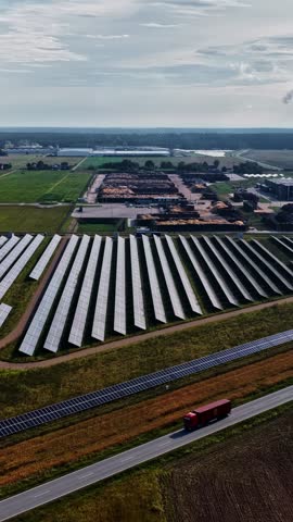 Aerial view of solar farm panels and a red truck driving on a road in Suwalki, Podlaskie Voivodeship, Poland.