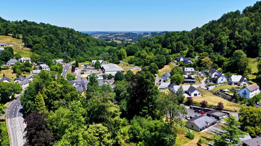 Aerial view of the village of Beost nestled in the green valley of the Pyrenees mountains with traditional houses and winding roads in Beost, Nouvelle-Aquitaine, France.
