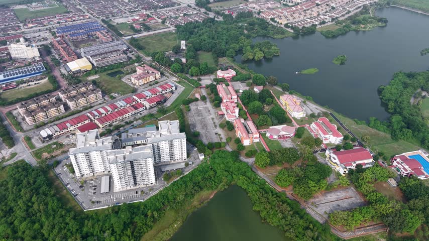 Aerial view captures a Universiti Tunku Abdul Rahman UTAR by a large lake. Red-roofed structures line the water
