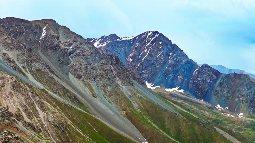 Aerial view of a rocky mountain peak with snow patches along the Duku Highway in Xinjiang, China