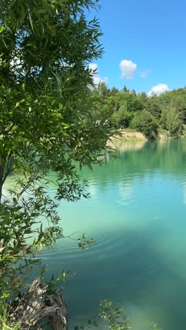 Scenic turquoise lake with clear water framed by green tree branches