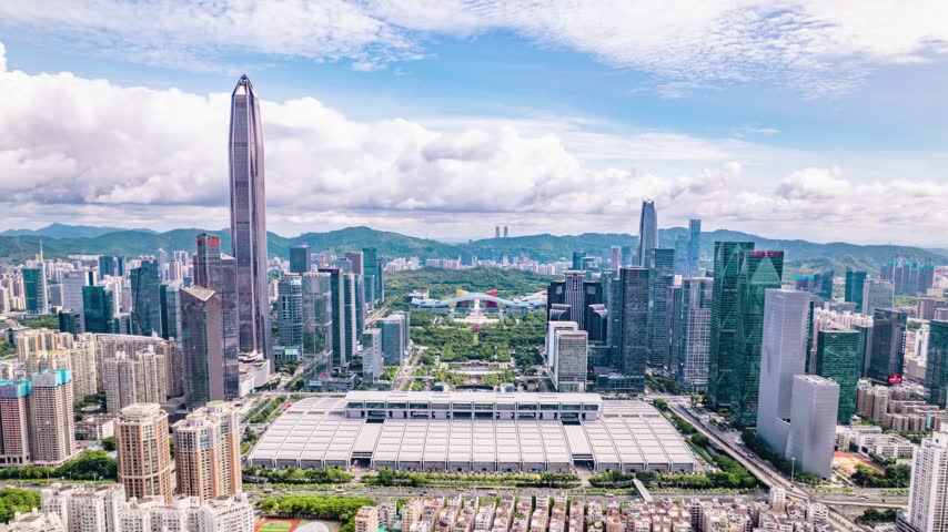 Aerial view of wide exhibition complex along the downtown axis in Shenzhen, Guangdong, China. The scene features Shenzhen Convention and Exhibition Center. Time-lapse footage. Relevant to venue architecture and urban development.