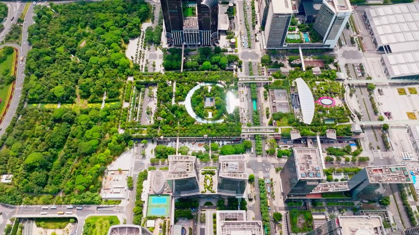 Overhead view of exhibition roof beside geometric plazas and gardens in Shenzhen, Guangdong, China. The scene features Shenzhen Convention and Exhibition Center. Relevant to venue architecture and urban development.