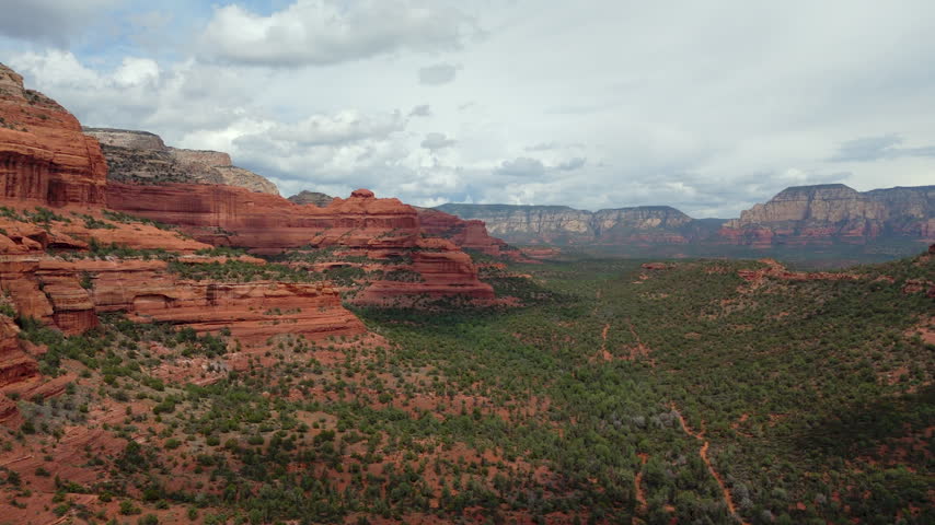 Scenic Red Rock Canyon Formations Rise Across The Rugged Desert Landscape Of Sedona, Arizona, USA. Aerial Drone Shot