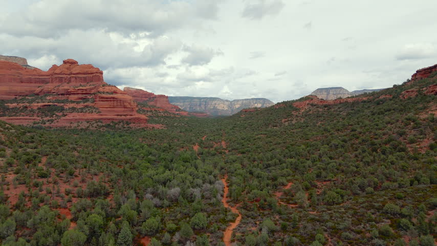 Red Rocks Landscape Rising Above Dense Forest In Sedona, Arizona, USA. Aerial Drone Shot