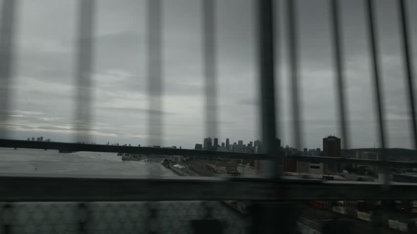 Jacques Cartier bridge pedestrian and bike path, camera moves from side fence and city skyline to forward along path, steel truss and river, Montreal, Quebec, Canada.
