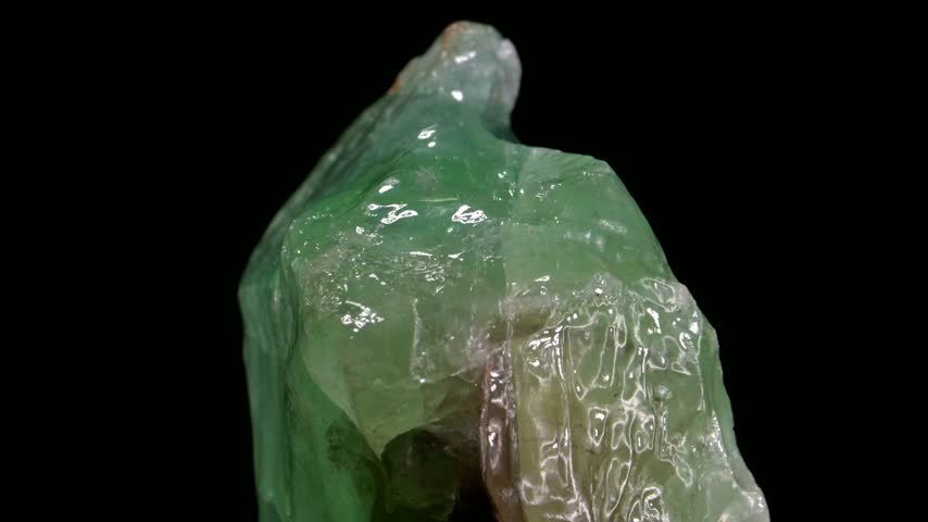 Green Calcite crystals rotating slowly against a black background