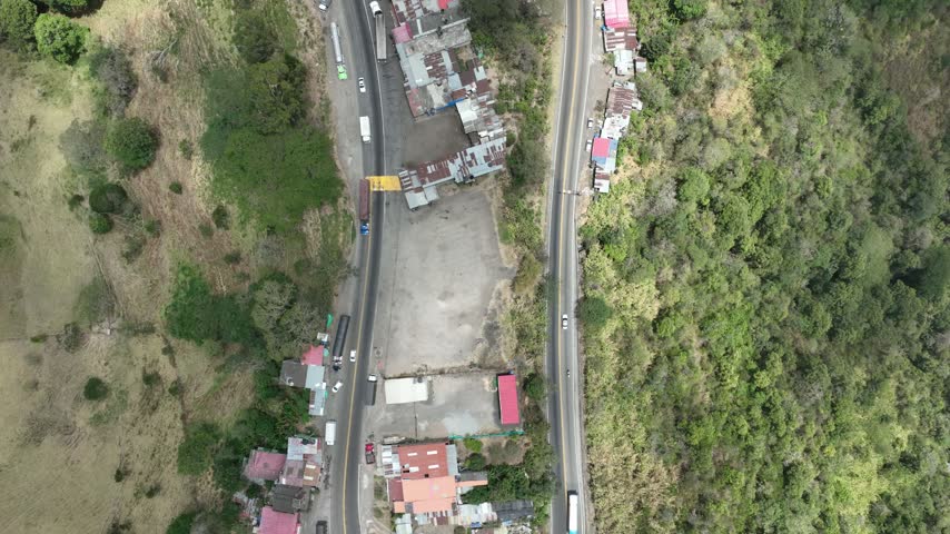 Mountain road with trucks and transport infrastructure on the highland corridor between Bogota and Honda, Colombia. Aerial view.