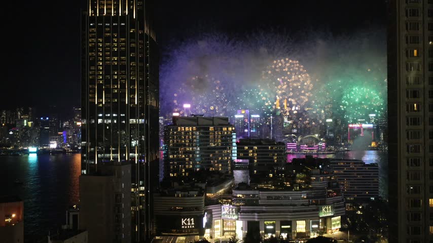 Wide view of fireworks over Hong Kong Victoria Harbour, full skyline and waterfront visible
