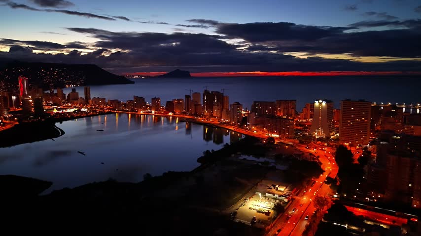 Dusk Harbor Skyline With Glowing Boulevard Lights, Calm Water Reflections, Suspended Clouds And Metropolitan