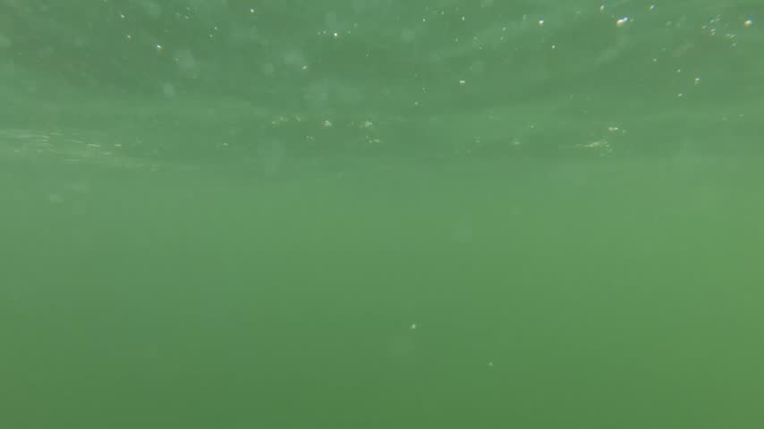 Underwater view transitions through bluish-green water to reveal Bridal Veil Falls in Kagawong on Manitoulin Island, Ontario, Canada.