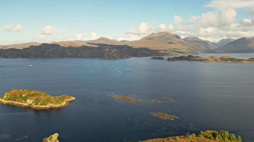 Scottish Scenery near Applecross in the Highlands, showing a tranquil loch surrounded by wooded peninsulas, rugged mountains and remote Highland landscape, aerial