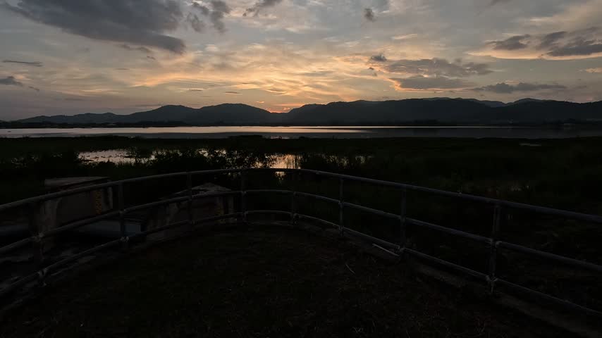 Silhouette of the dam landscape and public area at sunset; the light is fading.