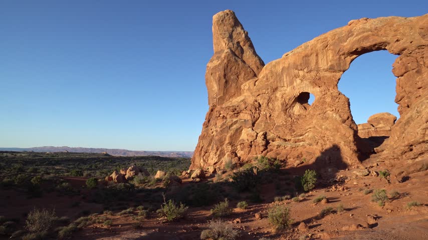Slow panning footage of a striking rock formation in Arches National Park, Utah. The shot reveals the rich red sandstone, desert textures, and dramatic natural shapes that define the park’s iconic landscape. A calm, atmospheric view of the American Southwest.