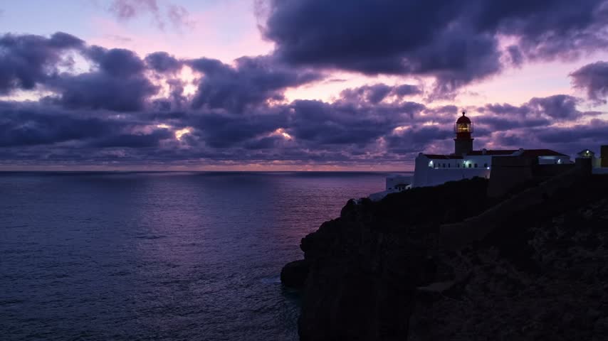 View of the Lighthouse of Cabo de Sao Vicente in Sagres, Algarve, Portugal, at dusk with evening surf and Atlantic ocean