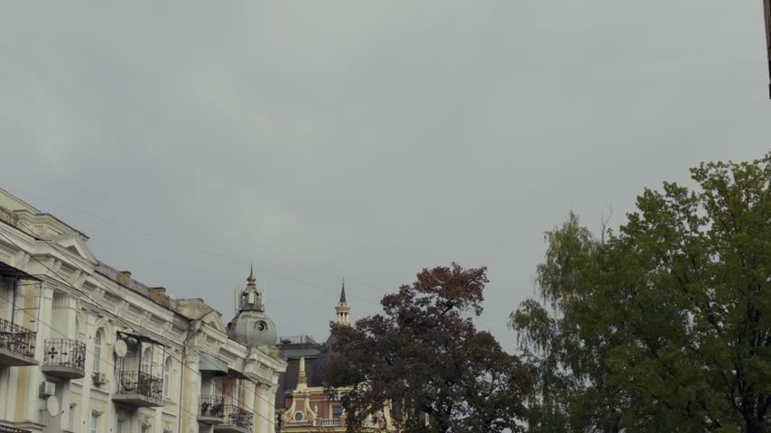 Historic Kyiv street view with old residential buildings decorative balconies autumn trees cloudy sky central district.