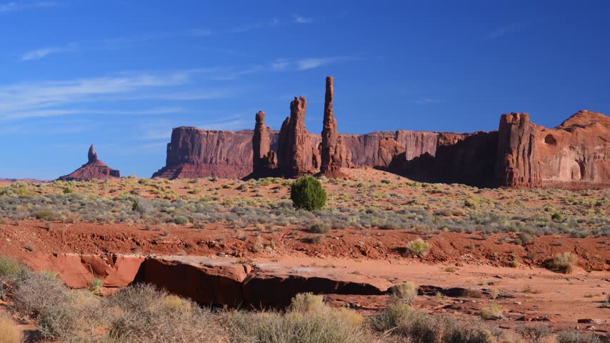 The famous rock formation Totem Pole and the neighboring Yei Bi Chei spires are located in Monument Valley, on the border between Arizona and Utah, USA. Totem Pole is a tall, slender rock pillar approximately 130 meters high, representing a heavily eroded remnant of an ancient rock massif. Yei Bi Chei consists of a group of thicker, vertical rock spires standing near Totem Pole. The formation is named after the healing spirits of the Navajo people.
