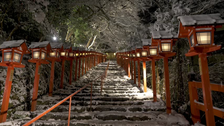 Kifune shrine stone stairs and traditional light pole in snowy winter night. Snow in Kyoto, Japan.