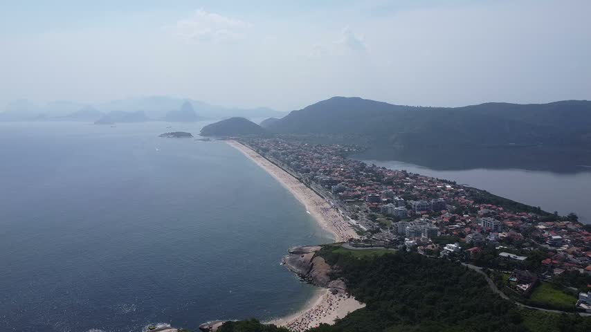 Wide aerial view of the coast, lagoon and neighborhoods near Camboinhas in Niteroi, Rio de Janeiro state, Brazil.