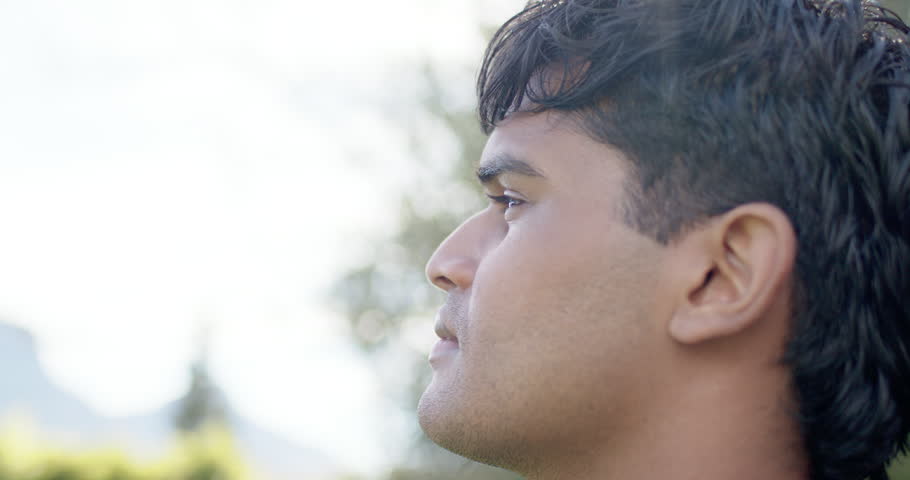 Adult male sensing sun flare, closing eyes, tilting head upward in park in jacket, reflecting. Portrait, outdoor, nature, profile, gaze, serene, bokeh