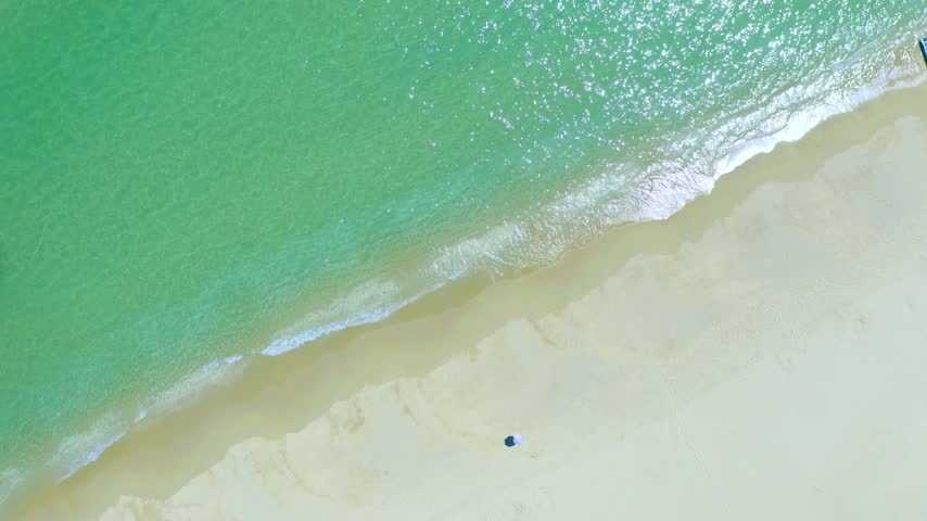 Aerial view of Yalong Bay beach shoreline with calm turquoise water and white sand