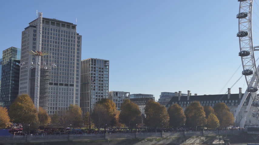 City Skyline Across Autumn Trees Under Clear Blue Sky
