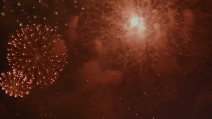 ​Spectacular red and purple fireworks explosions lighting up the night sky  
