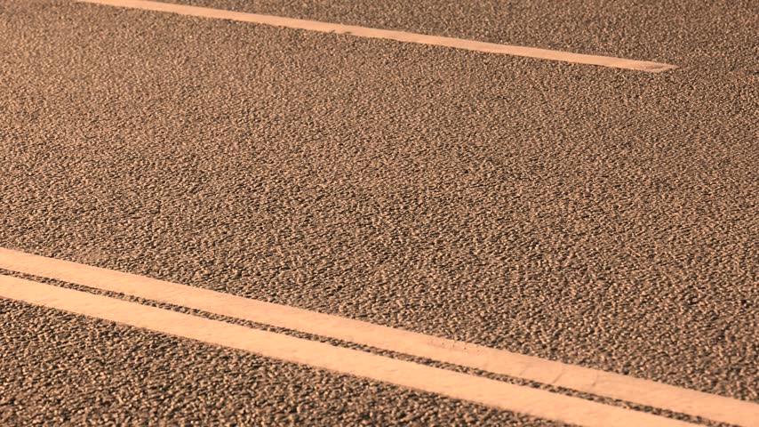 Detail of asphalt road surface with painted white lane markings