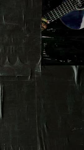 Dark, wrinkled, and torn poster paper glued to an urban wall, creating an abstract grunge background