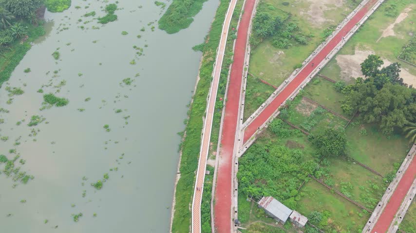 Aerial View of Red Brick Walking Trail Along Riverbank