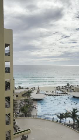 Tilt from stormy Caribbean sky down to a resort pool and beach, Cancun, Mexico