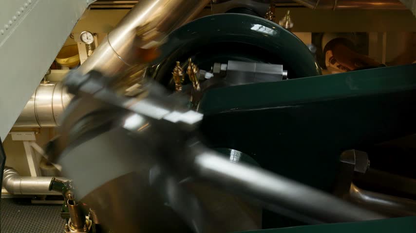 Close-up of a powerful vintage steam engine with its pistons and crankshaft rotating. Switzerland