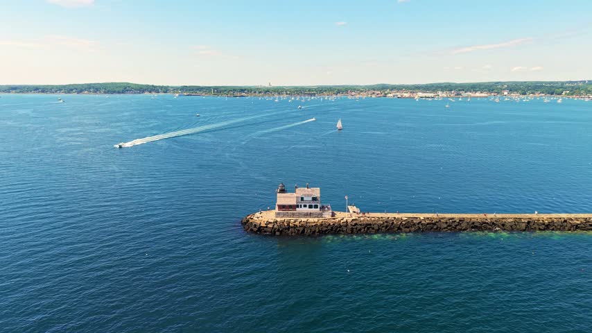 Rockland Breakwater Lighthouse standing at the end of a long granite breakwater surrounded by deep blue water in Penobscot Bay near Rockland, Maine.