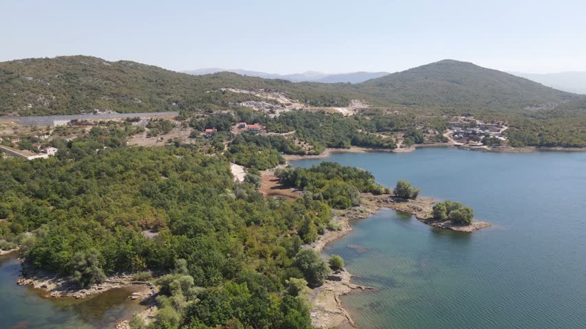 Drone aerial moving over Krupac Lake shoreline Montenegro and mountains landscape