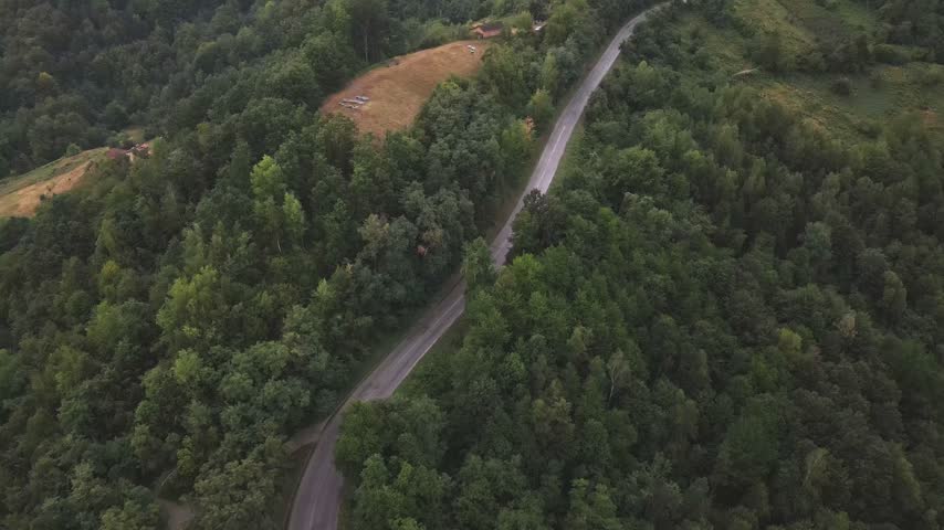Drone aerial over a road in western Serbia on a green mountain