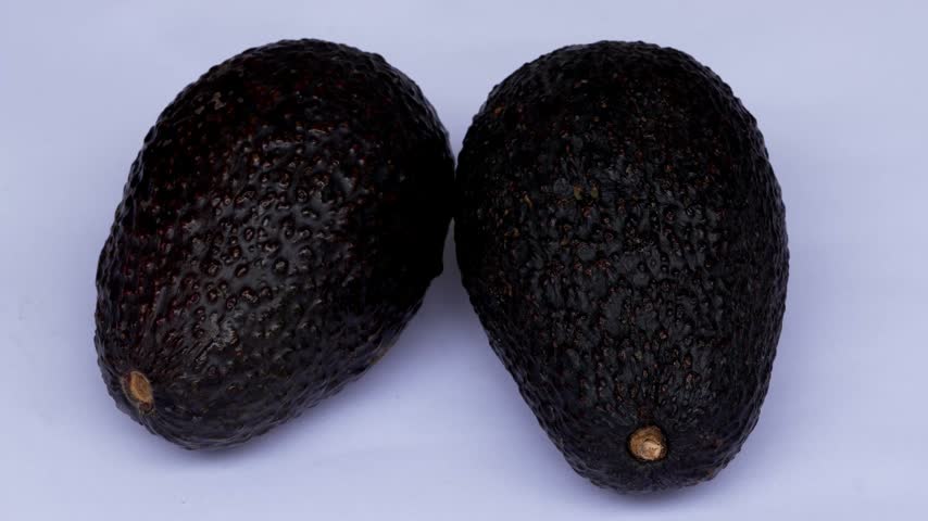 Fresh Hass avocados on clean white background in 4K macro
