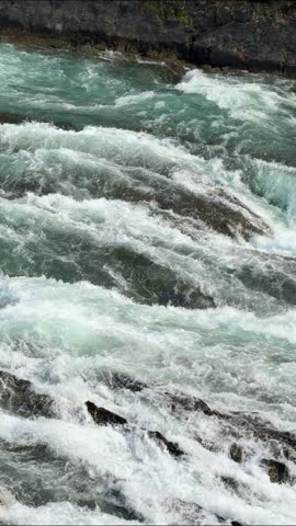 The powerful Bow Falls cascades over wide rock ledges on the Bow River at Banff National Park, Alberta, a scenic whitewater waterfall in the Canadian Rockies.