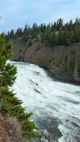 The powerful Bow Falls cascades over wide rock ledges on the Bow River at Banff National Park, Alberta, a scenic whitewater waterfall in the Canadian Rockies.