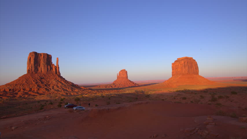 Time lapse of the Mitten buttes in Monument Valley from late dusk into night with a deep red desert landscape and fading light