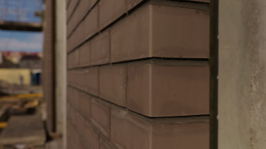 Close up of brown brick facade corner on building under construction