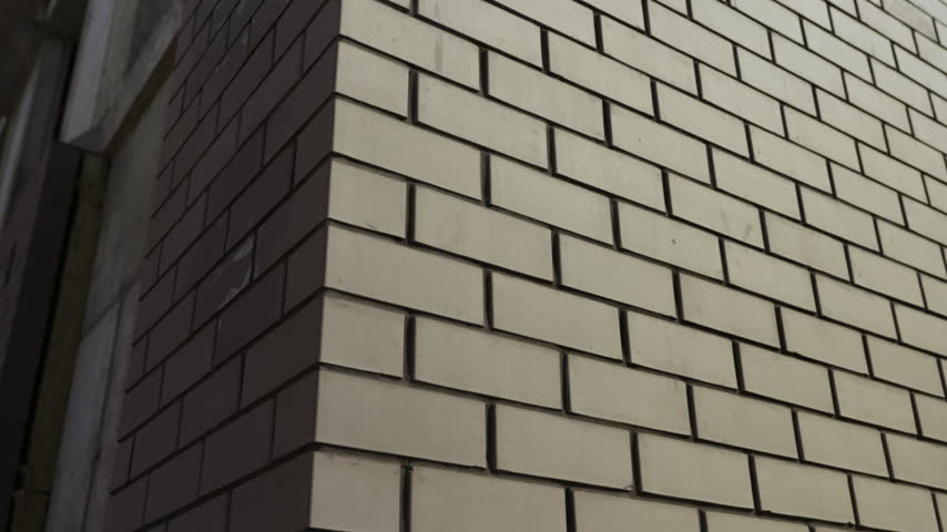 Close up of brick building corner with contrasting sunlight and shadow