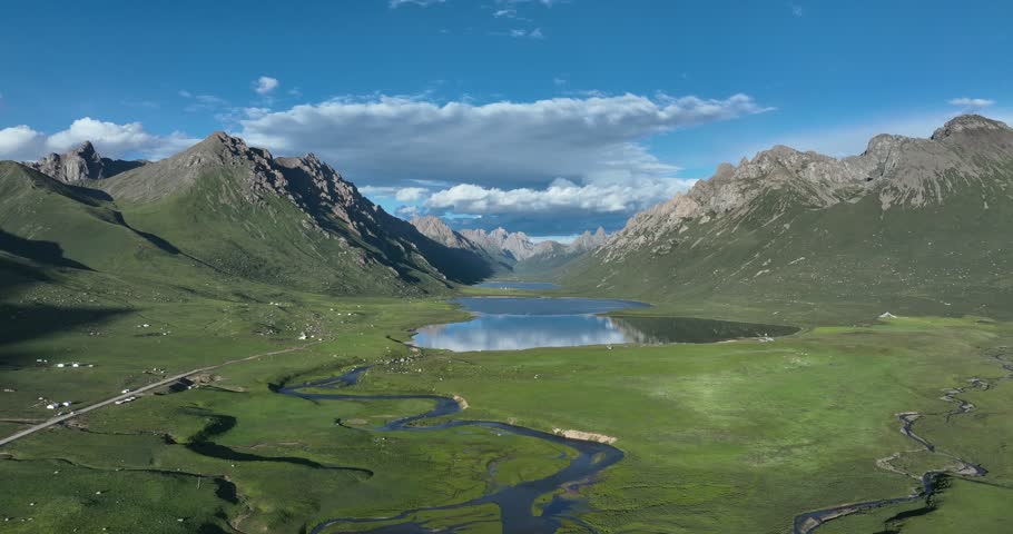 Beautiful green grassland and lake under cloudy sky	