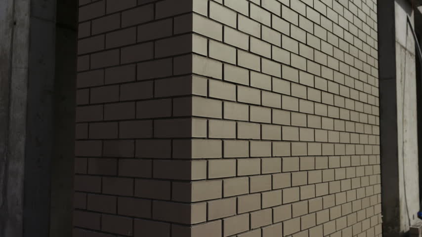 Close up of brick building facade corner with sunlight and shadow