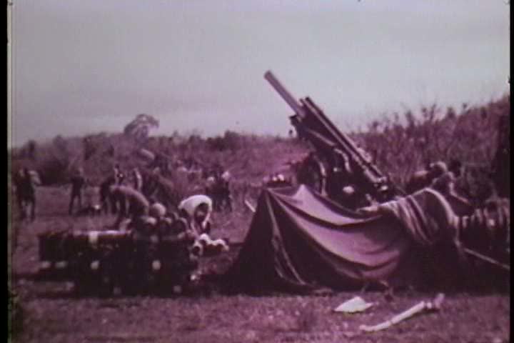 1960s - A battery of howitzers bombard enemy combatants during the Vietnam War