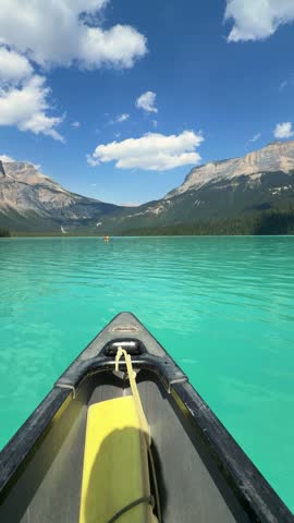 Point-of-view from a canoe gliding across the brilliant turquoise waters of Emerald Lake toward Mount Burgess at Yoho National Park, British Columbia, a Rockies adventure.